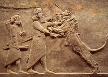 Assyrian wall relief, detail of panorama with royal lion hunt. Old carving from the Middle East history. Remains of culture of Mesopotamia ancient civilization. Amazing Babylonian and Sumerian art.